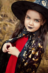 A girl with painted black lips dressed as a witch.  Halloween celebration. Portrait of a woman