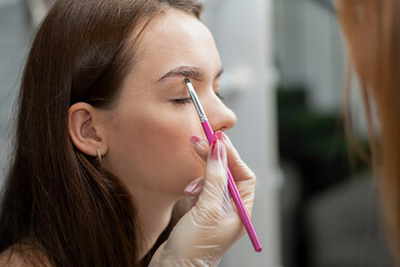 People. Beauty and health. Eyebrow flexing. The make-up artist corrects the eyebrows of a young...