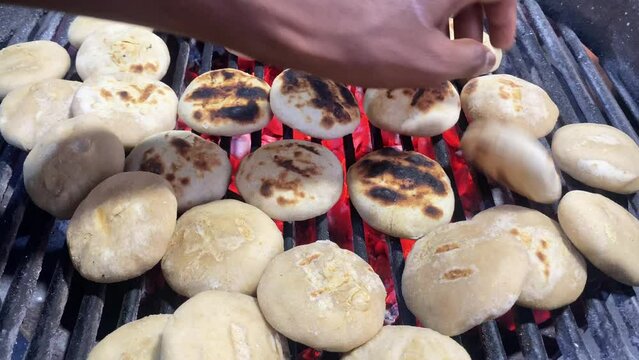 A street vendor in Kolkata can be seen in this video tossing litti over charcoal in an iron grill to cook it evenly so that it can be served with roasted mashed eggplant or baingan bharta and a green