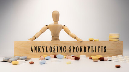 ankylosing spondylitis written on the surface. Wooden man and medicine concept