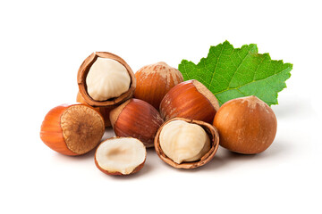 hazelnuts and peeled nuts with green leaves on white background.