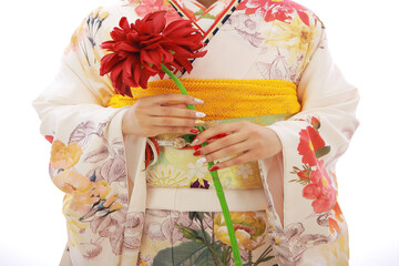 白い振袖を着て赤い花を持つ女性