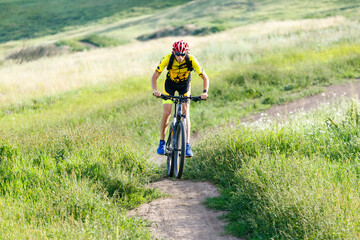 A cyclist in sportswear rides a mountain bike