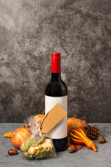Bottle of gift wine with autumn cookies. Gray background, fall Thanksgiving festival