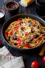 Spaghetti pasta Alla Puttanesca with capers, Kalamata olives, cheese, tomatoes and anchovies. Italian food.