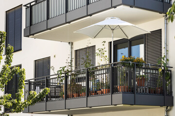 Balcony with Flowers for relax, Facade view. Decorated Modern Balcony Garden of Residential House with Shutters Windows. - obrazy, fototapety, plakaty