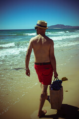 a man alone with a bag walking on a beach