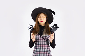 Halloween theme, young asian woman wearing witch hat posing on white background.