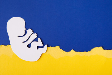 The concept of the child of Ukraine dreams of peace with the family. paper-cut family painted in the national colors of Ukraine. Ukrainian flag - obrazy, fototapety, plakaty