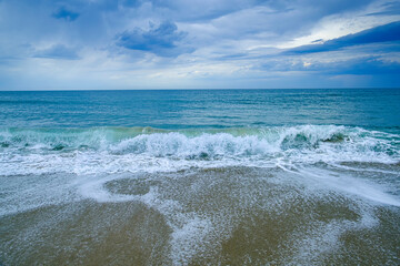 vagues sur la plage et ciel nuageux