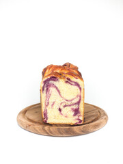 sliced babka brioche with purple sweet potato filling on round wooden plate