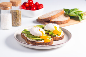 Two avocado open sandwiches with egg. Keto and diet concept. Healthy toast food for breakfast.