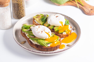 Two avocado open sandwiches with egg. Keto and diet concept. Healthy toast food for breakfast.