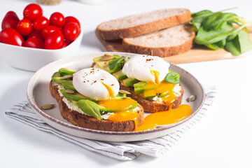 Two avocado open sandwiches with egg. Keto and diet concept. Healthy toast food for breakfast.