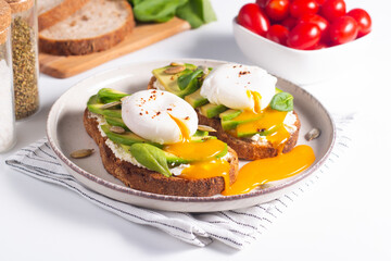Two avocado open sandwiches with egg. Keto and diet concept. Healthy toast food for breakfast.