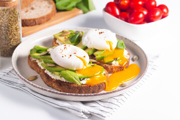 Two avocado open sandwiches with egg. Keto and diet concept. Healthy toast food for breakfast.