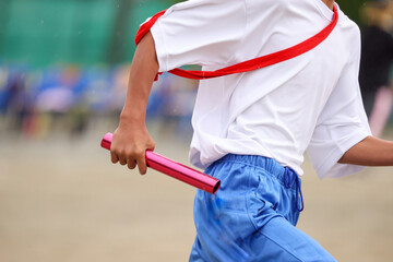 運動会、リレーのバトンを持つ手