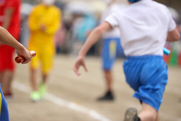 運動会、リレーのバトンを持つ手