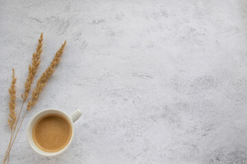 Cup of coffee cappuccino, latte and dry pampas grass on white table background. Cozy beige autumn,...
