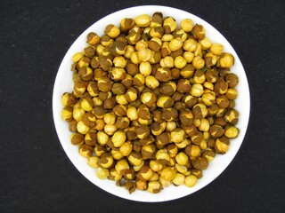 Roasted chickpeas on a plate on black background 