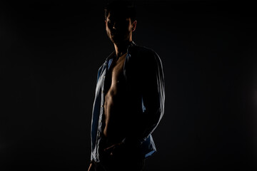 Male model posing in a light dimmed room