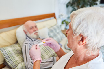 Fototapeta premium Pflegerin vom Pflegedienst beim Fieber messen bei Senior