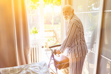 Mann als Senior Patient mit Rollator nach Schlaganfall