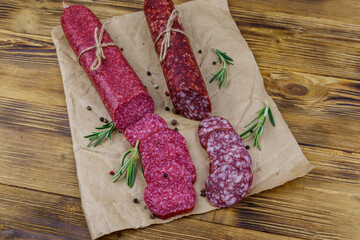 Salami sausages on craft paper on a wooden table