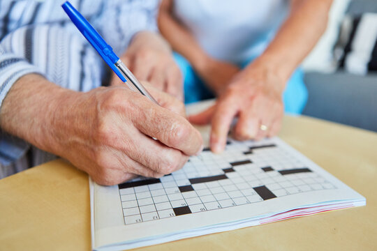 Senioren machen Kreuzworträtsel als Gedächtnistraining