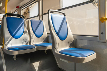 New comfortable seats inside a modern public bus. Seats on the bus for the elderly, people with...