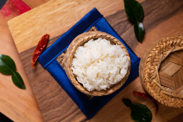 Asian Food concept Glutinous rice or Sticky rice in bamboo wicker on wooden board and black background with copy space