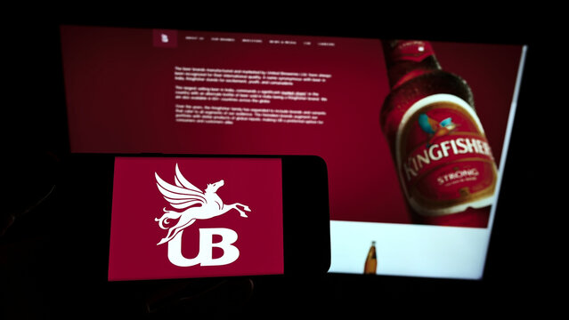 Stuttgart, Germany - 12-12-2021: Person holding smartphone with logo of company United Breweries Holdings Limited (UBHL) on screen in front of website. Focus on phone display.