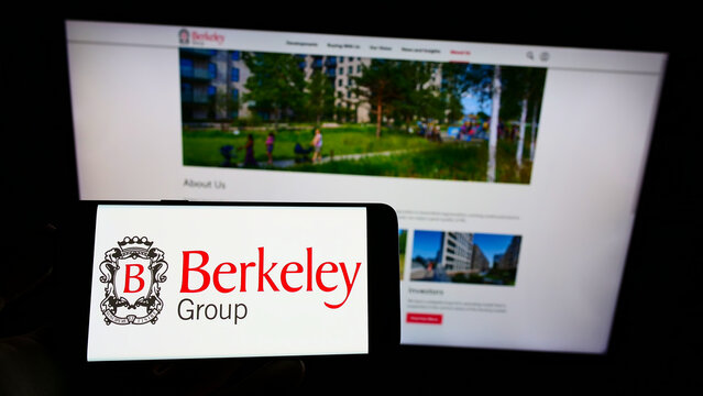 Stuttgart, Germany - 12-12-2021: Person holding cellphone with logo of British company The Berkeley Group Holdings plc on screen in front of webpage. Focus on phone display.