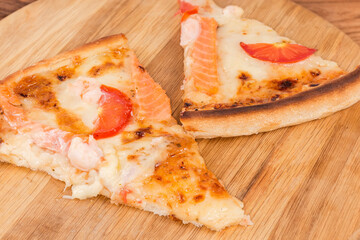 Slices of pizza with seafood on pizza board, close-up