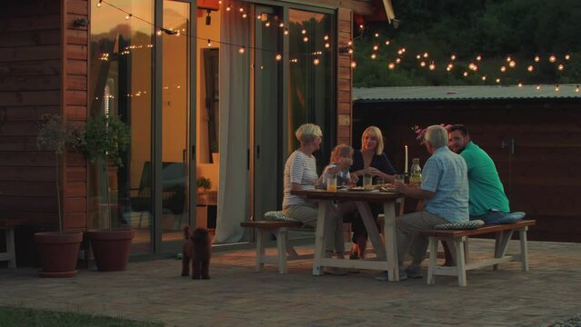 Three generations family family during dinner in the backyard