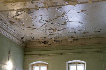 Paint is peeling off the ceiling in an old building.
