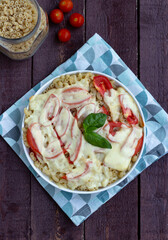 Baked pasta with cheese and tomatoes in a round shape. View from above.