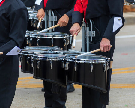 snare section of a marching band drum line warming up for a parade