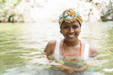 young black woman in a river in nature scene