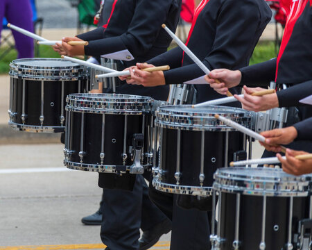 bass section of a marching band drum line warming up for a parade