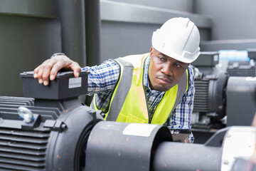 Male plumber engineer working in sewer pipes area at construction site. African American male plumber worker maintenance sewer pipes network system at construction site