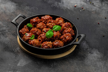 Meatballs with tomato sauce in frying pan on dark background, Long banner format. top view
