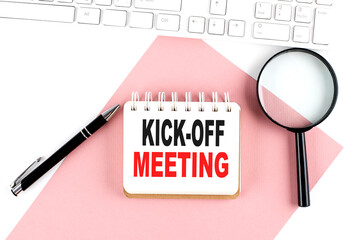 Business concept. Notebook with text KICK-OFF MEETING on pink paper with magnifier, keyboard and...