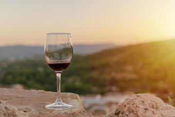 Glass of red wine with background of mountains and sunset light