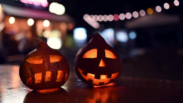 two carved pumpkins during the halloween celebration at night in the city.