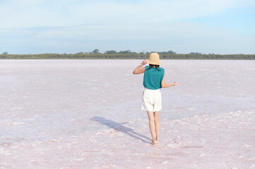 A woman standing on the pink lake