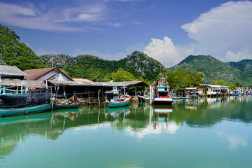 Fototapeta na wymiar Fishing Village view in summer fisherman house near big river and mountain hill view background near gulf bay of southern sea of thailand