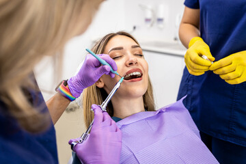 Female dentist with assistant working in dental clinic gives anesthesia to the patient.
