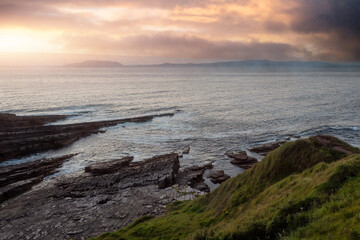 Sunset sky over the ocean water surface. Warm and cool tone. Calm and peaceful mood. Nature background. Ocean waves and clouds.