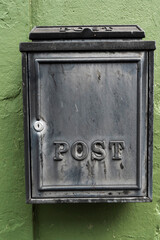 Old metal mailbox on a green wall. Retry style.
